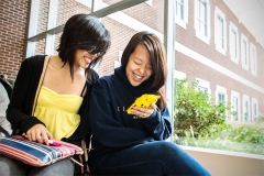 Students look at a phone in the Student Dining and Residential Programs Building.